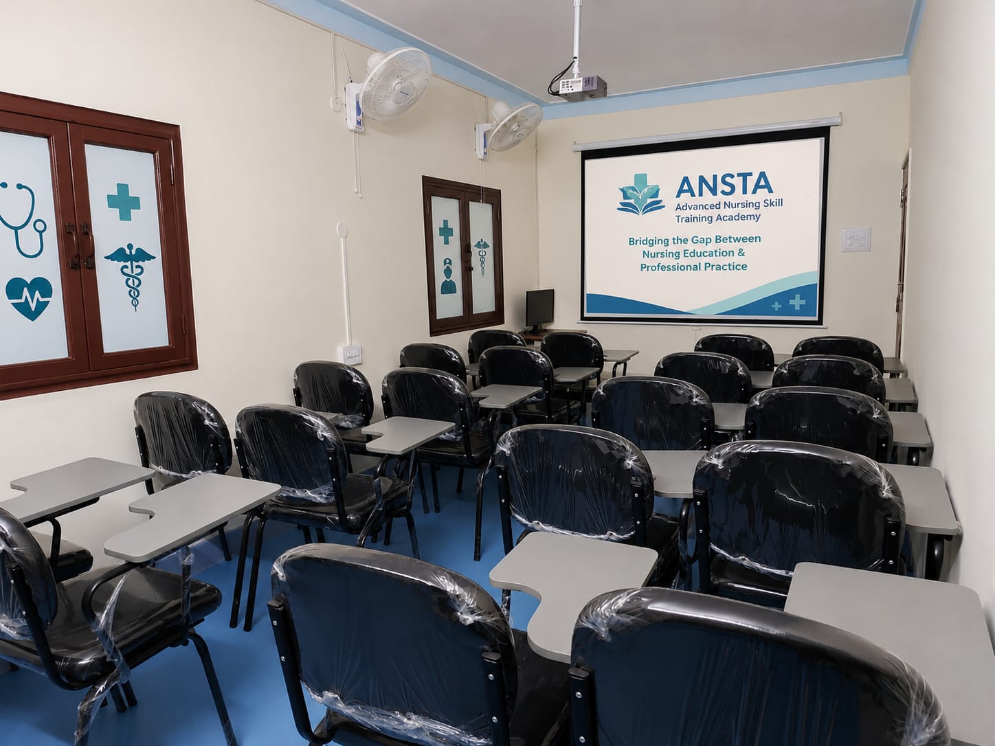 ANSTA skills classroom with projector screen showing the academy logo and student desks